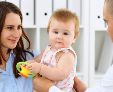 Happy Cute Baby With Her Mother At Health Exam At Doctor's Office.